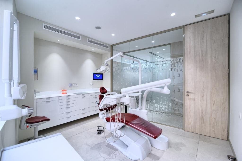 Sala odontologica con silla odontologica con acabado en blanco y rojo