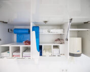 Mueble dispensador con productos de higiene bucodental acabados en blanco