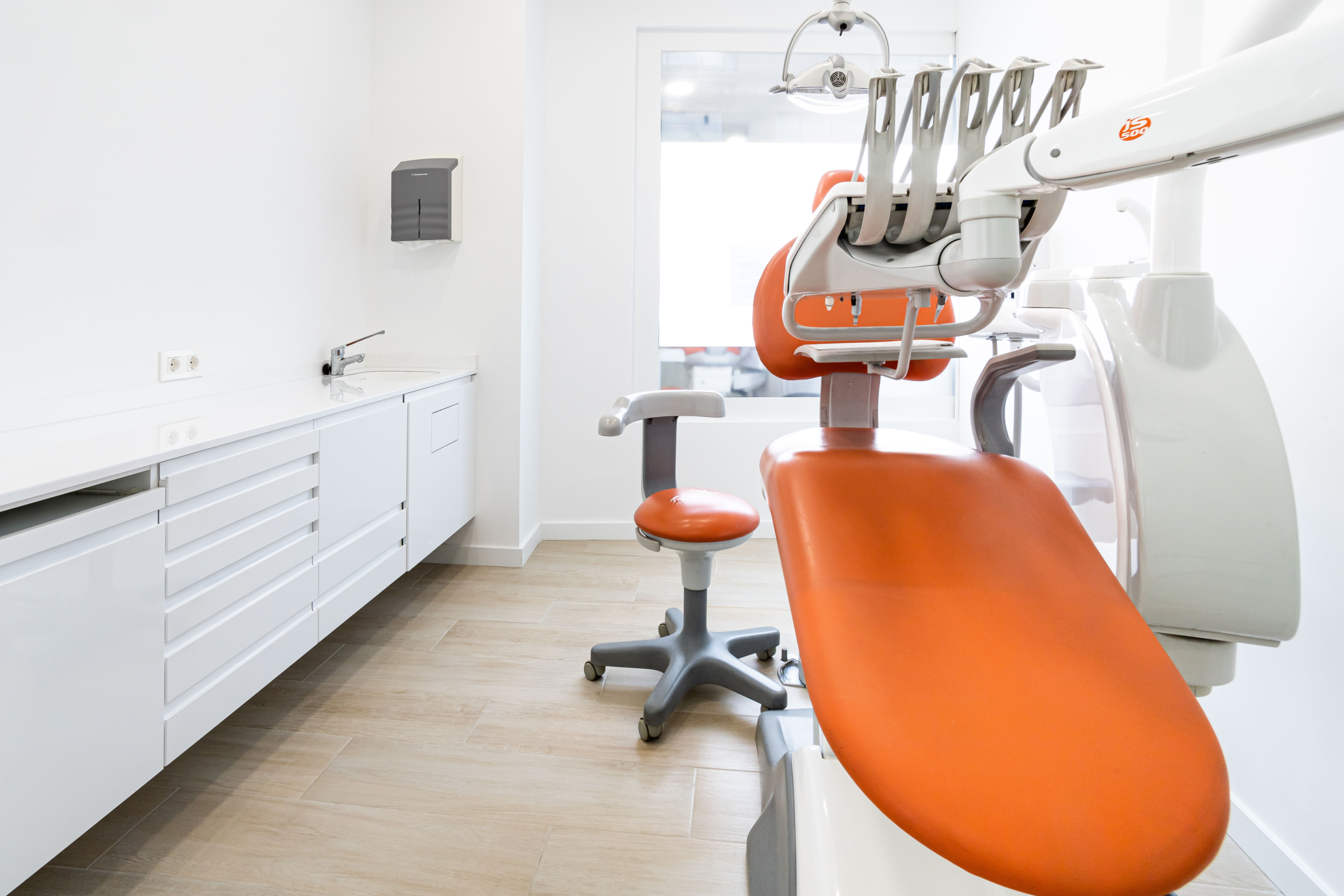 Mobiliario protesico silla dental en blanco y naranja con encimera acabada en blanco