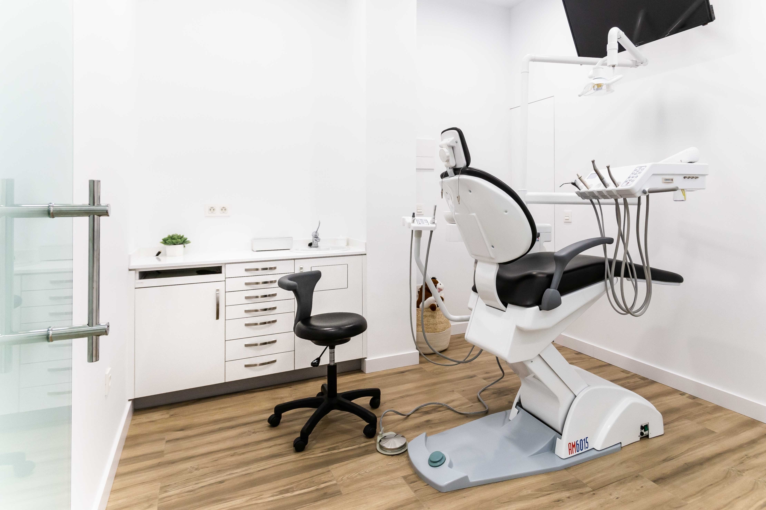 Mobiliario protesico con encimera y silla dental en blanco y negro y muebles dispensadoras