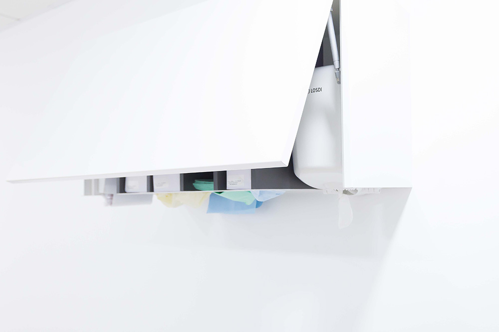 Mueble dispensador con productos de higiene bucodental acabados en blanco