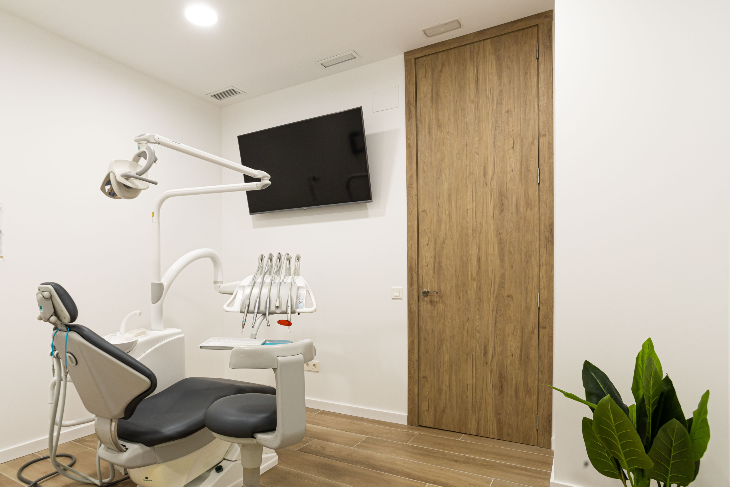 Mobiliario protesico silla dental en blanco y negro, con pantalla y puerta acabada con madera