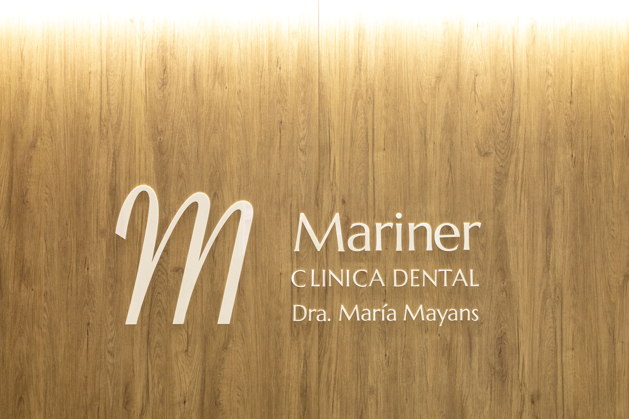Diseño de logo dentista con una M grande acabado en blanco