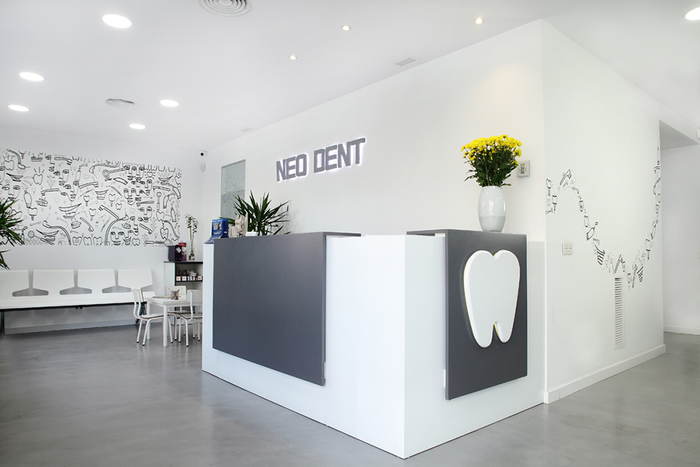 Sala de recepcion con nombre Neodent con acabados blancos y grises con el logotipo de un diente
